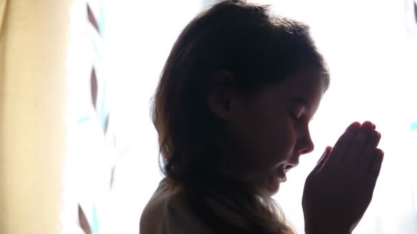 child teen girl praying prays silhouette in window video hd 1920x1080 - Footage, Video