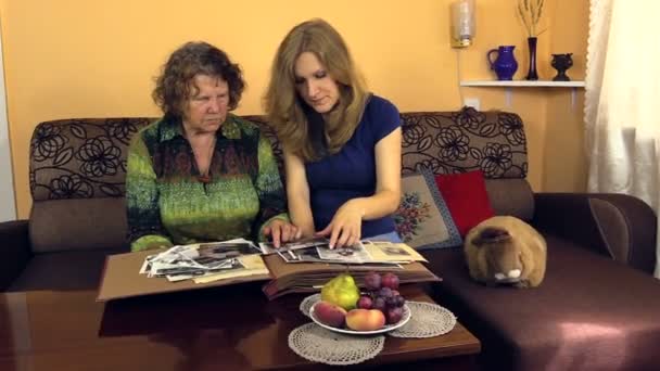 Granny watch black white old photo album with her granddaughter - Footage, Video