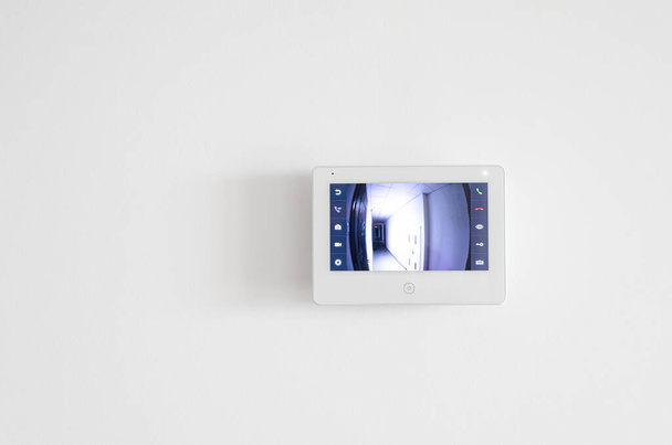 Egy fehér videó intercom képernyő egy fehér lakás falán. Biztonság - Fotó, kép