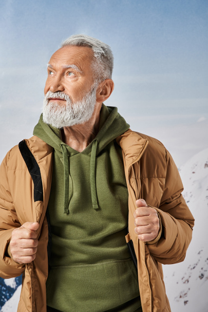 Porträt des Weihnachtsmannes mit weißem Bart, der mit Bergen und Bäumen im Hintergrund wegschaut, Winterkonzept - Foto, Bild