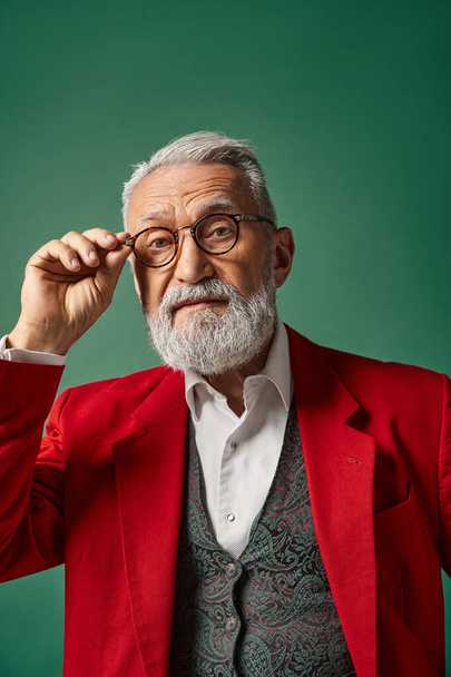 portrait of classy handsome Santa touching his glasses and looking at camera, winter concept - Fotografie, Obrázek