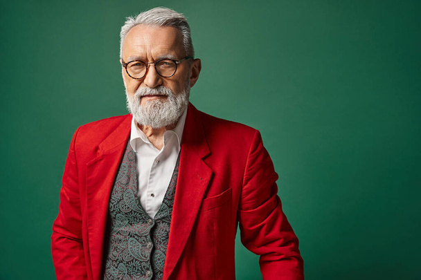 stylish classy man dressed as Santa with glasses and beard looking at camera, winter concept - 写真・画像