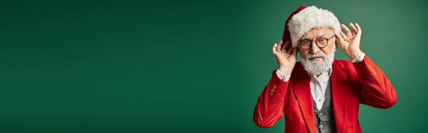 goed uitziende witte baard Kerstman aanraken van zijn rode hoed en kijken naar camera, winter concept, banner - Foto, afbeelding