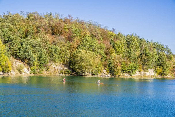 die wunderschöne Herbstlandschaft des Sees. Menschen auf Brettern - Foto, Bild