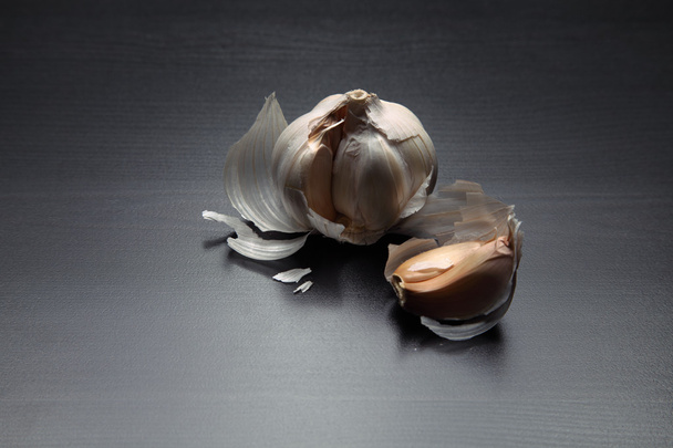 Image of garlic on black wooden table - Foto, Imagem