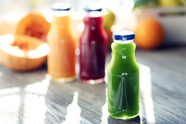 Bottles of juice with fruits and vegetables  on windowsill close up - Foto, afbeelding