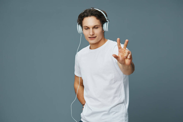 kék férfi portré háttér hallgatni audio érzelem fiatal élvezni elszigetelt életmód stúdió boldog online diák modell tánc fülhallgató póló vezeték nélküli zene - Fotó, kép