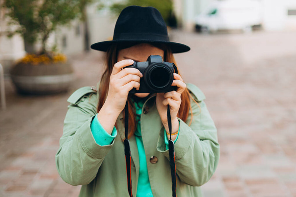 Mulher fotógrafa com dcâmera tirando fotos ao ar livre. Casa hobby, estilo de vida, viagens, conceito de pessoas - Foto, Imagem