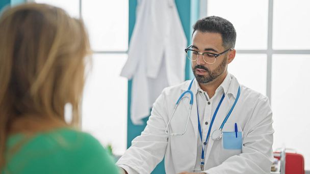 Чоловік і жінка-лікар мають медичну консультацію, що розмовляє з пацієнтом у клініці - Фото, зображення