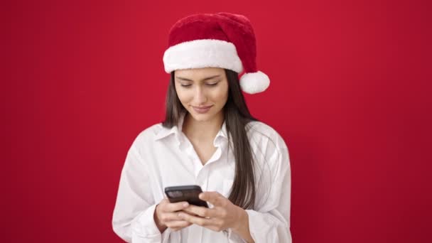 Mladá krásná hispánská žena pomocí smartphone slaví Vánoce - Záběry, video