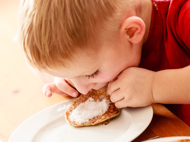 Little boy eating apple pancakes at home - Valokuva, kuva