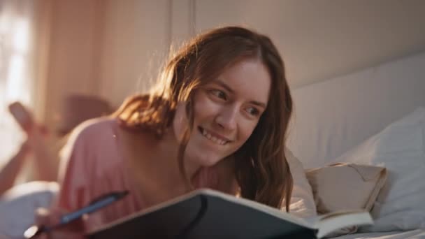 Romantic girl holding diary book at home closeup. Inspired joyful woman dreaming closing notebook in hands. Relaxed happy lady share thoughts contemplate relationship. Carefree model enjoy free time. - Footage, Video