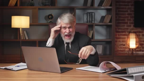 Elderly businesman in formal attire taking of spectacle when suffering from severe pain in temples in office. Tired caucasian employee experiencing migraine desease caused by fatigue on workplace. - Footage, Video