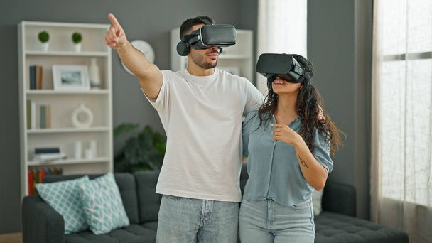 Чоловік і жінка пара грають у відеоігри, використовуючи окуляри віртуальної реальності вдома
 - Фото, зображення
