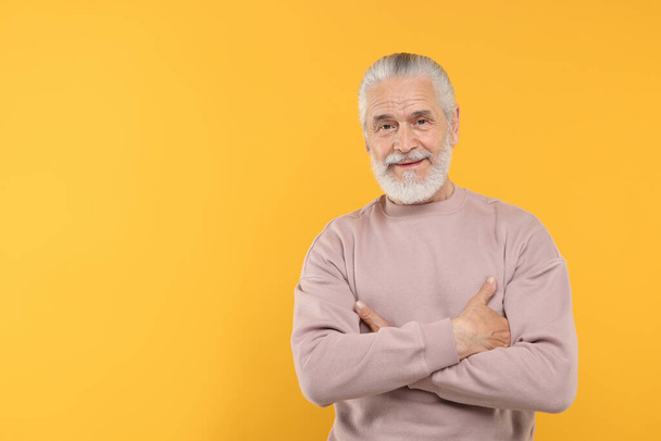 Portrait of handsome senior man on orange background. Space for text - Foto, afbeelding