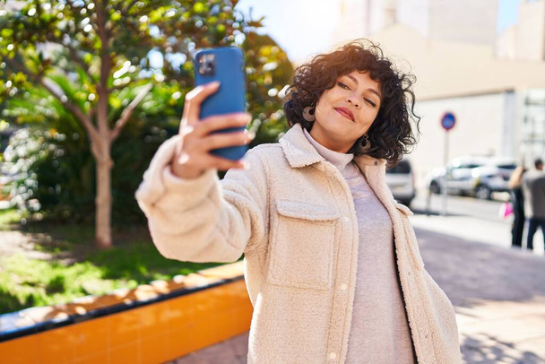 Jeune belle femme hispanique souriant confiant faire selfie par le smartphone au parc - Photo, image