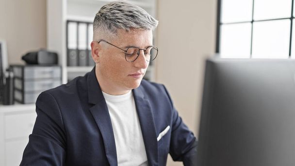 Молодий кавказький чоловік бізнесмен використовує комп'ютер, що працює в офісі - Фото, зображення