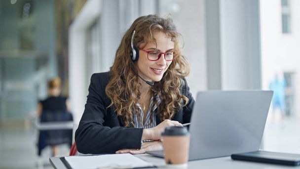 Молода жінка бізнесмен має відеодзвінок посміхається в офісі - Фото, зображення