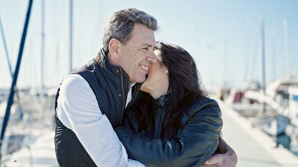 Senior uomo e donna coppia sorridente fiducioso abbracciarsi a vicenda al porto - Foto, immagini