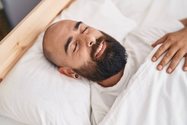 Fiatal kopasz férfi fekszik az ágyon alszik a hálószobában - Fotó, kép