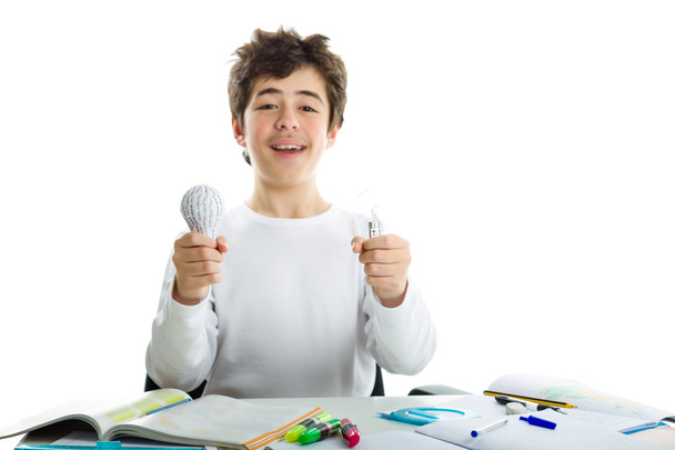 jongen holding echte lightbulb en 3d print prototype op huiswerk - Foto, afbeelding