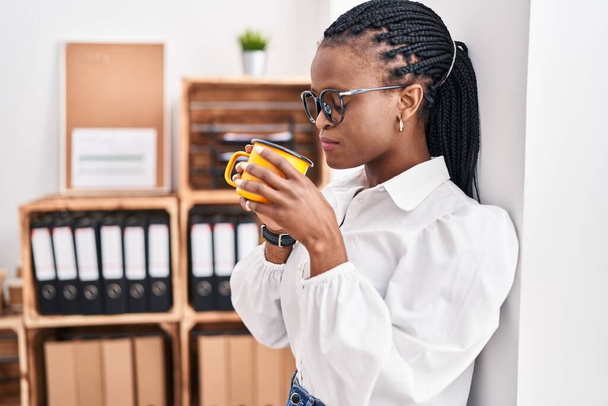 Trabajadora de negocios afroamericana bebiendo café en la oficina - Foto, imagen