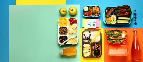 Различные вкусная еда в обеденных коробках и липкие заметки с текстом Обед ВРЕМЯ на цветном фоне с местом для текста - Фото, изображение