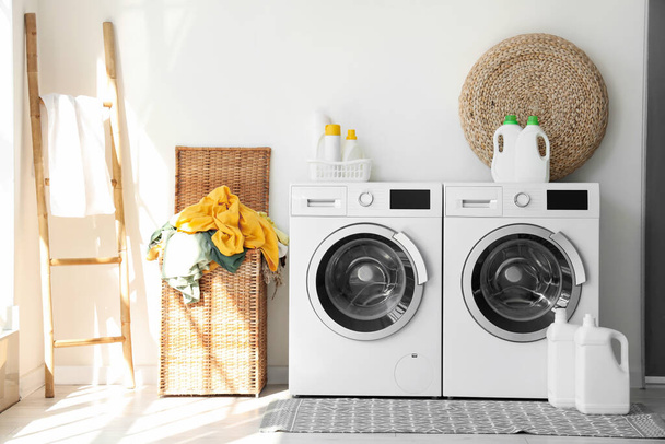 Interior of laundry room with washing machines and dirty clothes in basket - Photo, Image