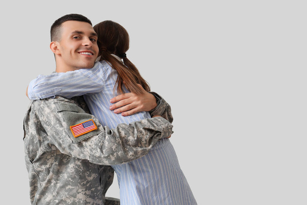 Voják se svou dcerou objímající se na světlém pozadí. Slavnost Dne veteránů - Fotografie, Obrázek