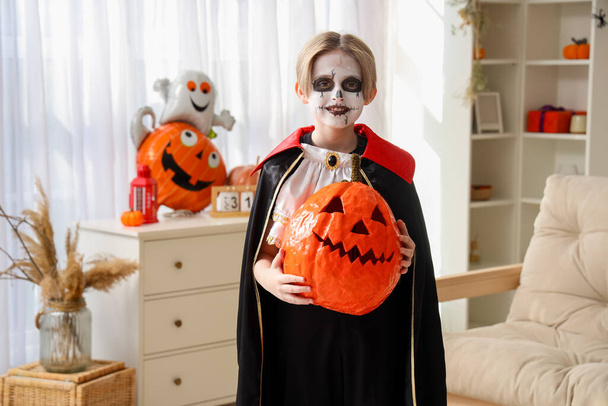 Маленький мальчик с тыквой празднует Хэллоуин дома - Фото, изображение