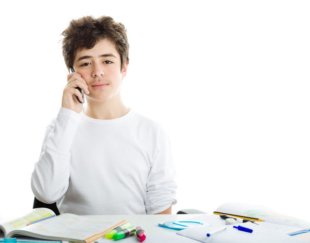 Boy talking on mobile phone on homeworks - Фото, изображение