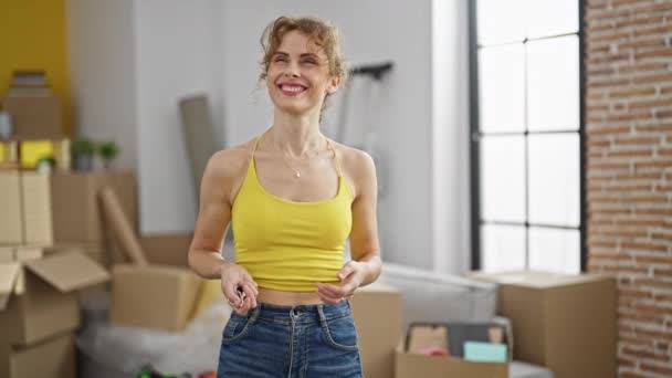 šťastná žena drží karton v ruce při stěhování nového bytu. - Záběry, video