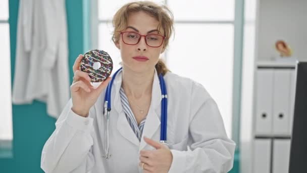 Nainen lääkäri osoittaa donitsi ja peukalo alas - Materiaali, video
