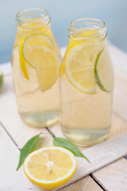 Свежий холодный лимонный напиток с ломтиками лайма и лимона
 - Фото, изображение