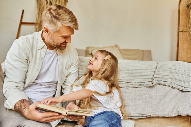 veselý otec a roztomilá dcera sedí na podlaze v ložnici a čtení knihy, učení společně - Fotografie, Obrázek