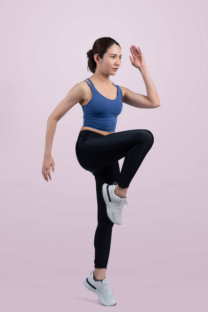 Side view young athletic asian woman on running posture in studio shot on isolated background. Pursuit of healthy fit body physique and cardio workout exercise lifestyle concept. Vigorous - Foto, imagen