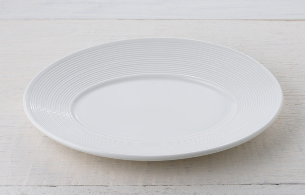 Prázdný bílý keramický talíř na dřevěném stole - Fotografie, Obrázek
