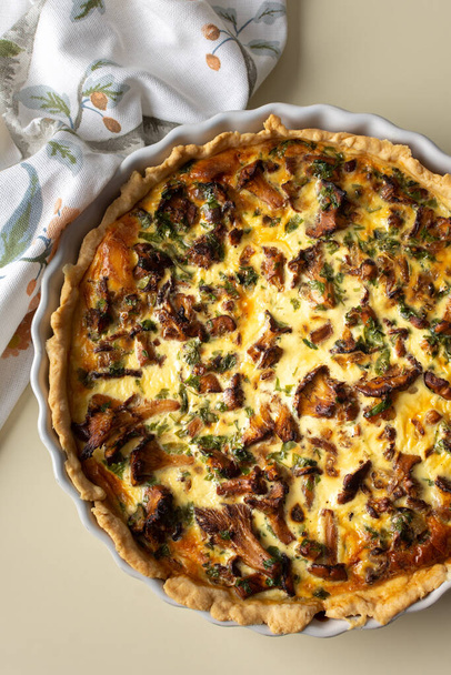 Homemade quiche with seasonal forest mushrooms Chanterelles in a round shape on a yellow background - Photo, Image