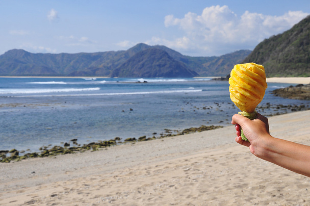 Резной ананас в руке, пляж
 - Фото, изображение
