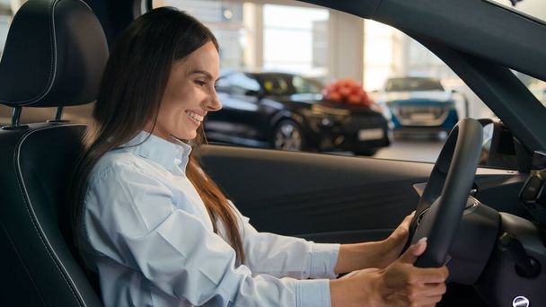 Ευτυχισμένος Καυκάσιος επιτυχημένη επιχειρηματίας χαρούμενη γυναίκα κάθονται σε νέο αυτοκίνητο στο κατάστημα αυτοκινήτων ενοικίαση αντιπροσωπείας υπηρεσία αποφασίσει να επιλέξει ενοικίαση αυτοκινήτου αγορά πολυτελείας μοντέρνα αγορά οχημάτων θηλυκό δοκιμή οδήγησης - Φωτογραφία, εικόνα