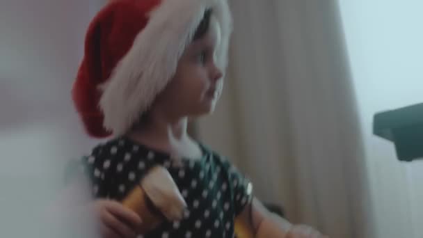 Little girl eating ice cream and dancing at a home Christmas party. Joyful atmosphere - Footage, Video