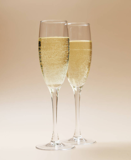 Two champagne glasses on a beige background - Photo, Image
