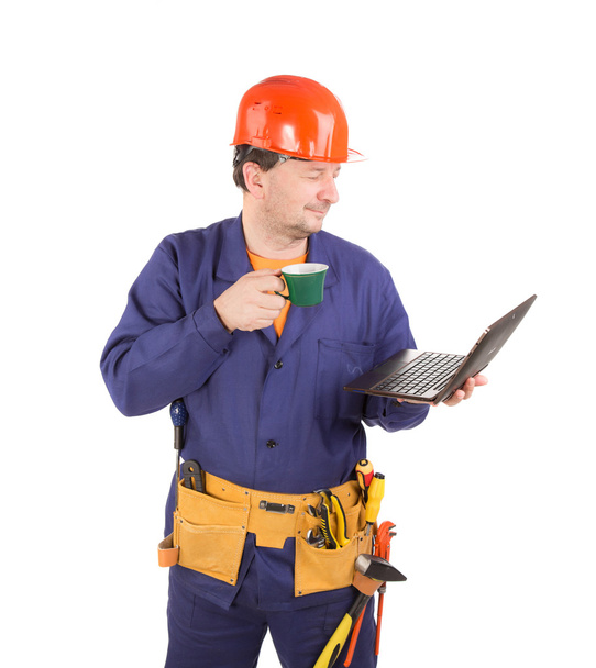 Worker with cup of coffee and laptop. - Zdjęcie, obraz
