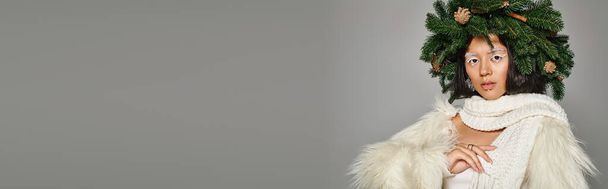 Beyaz göz makyajı ve gri arka planda çelenk şeklinde poz veren boncuklu kış kraliçesi bayrağı. - Fotoğraf, Görsel