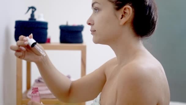 Lustro moment: Kobieta poprawia swoją pielęgnację skóry anti-aging, za pomocą kroplomierza serum do stosowania kwasu hialuronowego w domu.  - Materiał filmowy, wideo