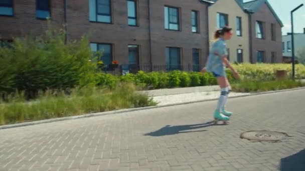 Drei kaukasische Mädchen in Vintage-Kleidung fahren mittags auf Rollschuhen in der Vorstadt herum - Filmmaterial, Video
