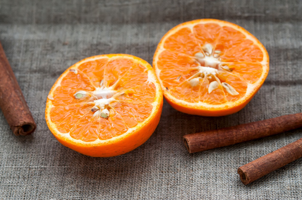 Fruit set - orange tangerine half and cinnamon sticks on hessian linen fabric cloth - Photo, image