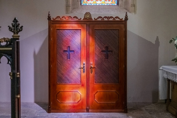 Un confessionale all'interno di una chiesa, uno spazio privato per la confessione dei fedeli. - Foto, immagini