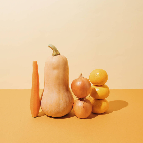 Kreatywnie ułożone dyni, słodkie ziemniaki, cebula i mandarynki zbliżenie. Pojęcie naturalnej zdrowej żywności pomarańczowej - Zdjęcie, obraz