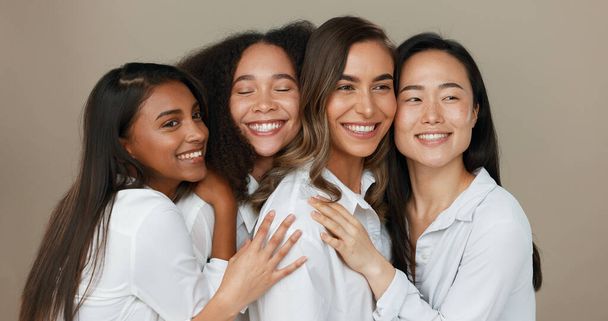 Women, group skincare and beauty with love, hug and support in diversity and inclusion on brown studio background. Friends, model or people smile together and kiss in dermatology, skin care or makeup. - Photo, Image